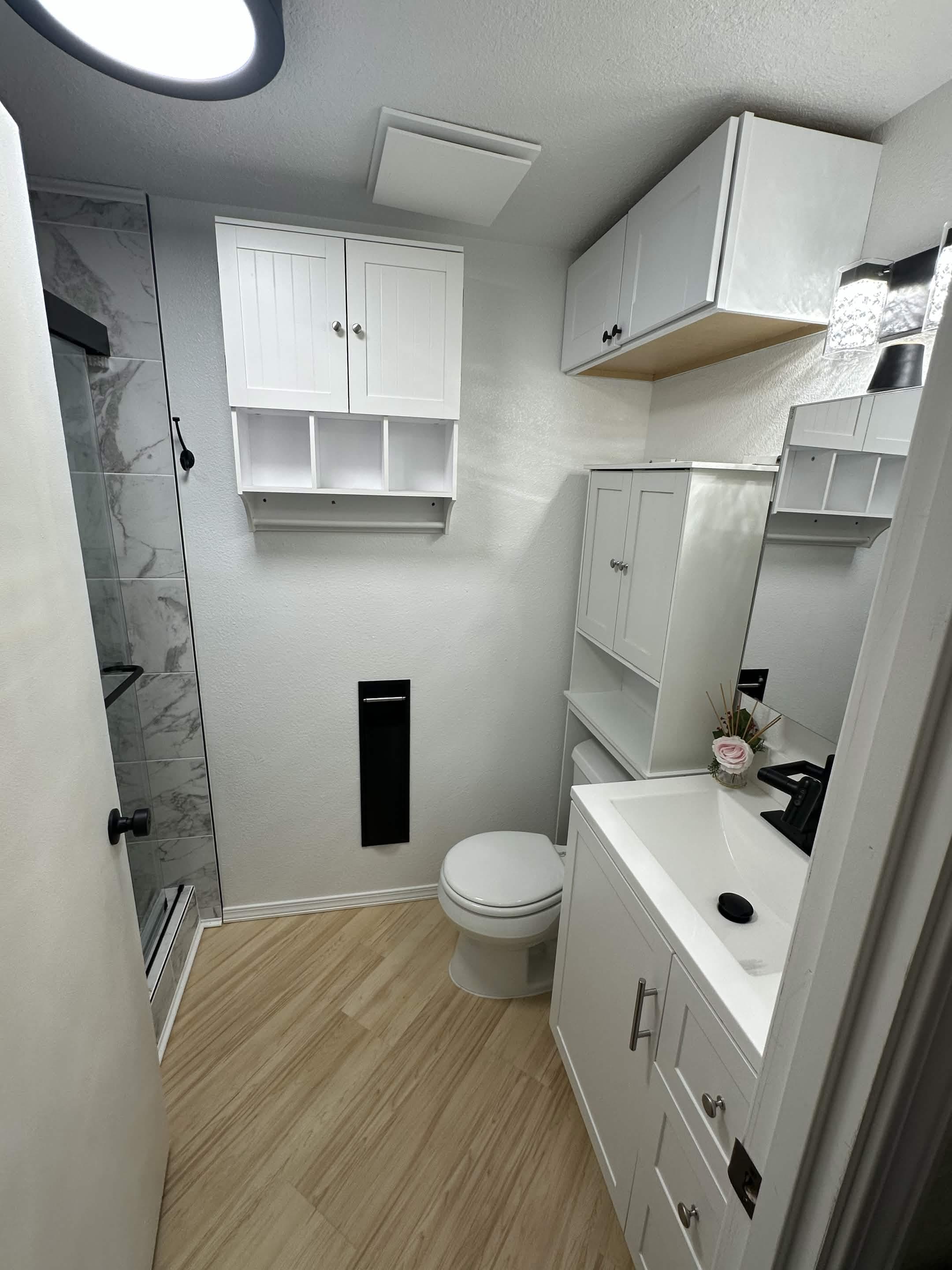 Renovated bathroom with white shaker cabinets, vanity, and walk-in shower